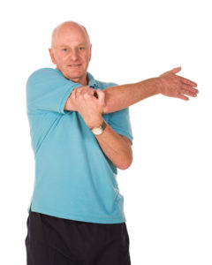 Senior older man performing stretching exercises before gym workout