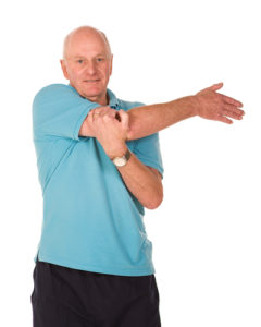 Senior man stretching Senior older man performing stretching exercises before gym workout
