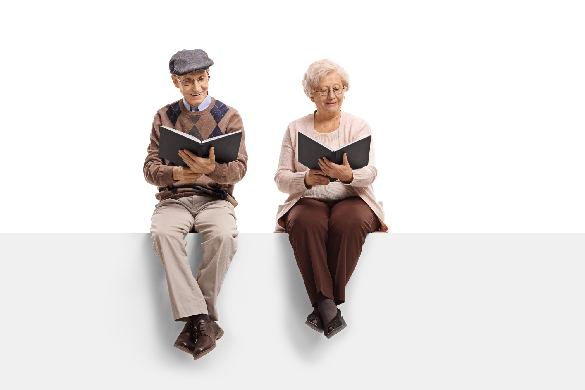 Seniors seated on a panel reading books isolated on white background